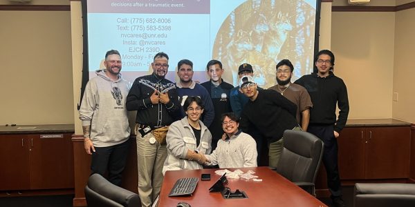 students posing in front of a projector screen